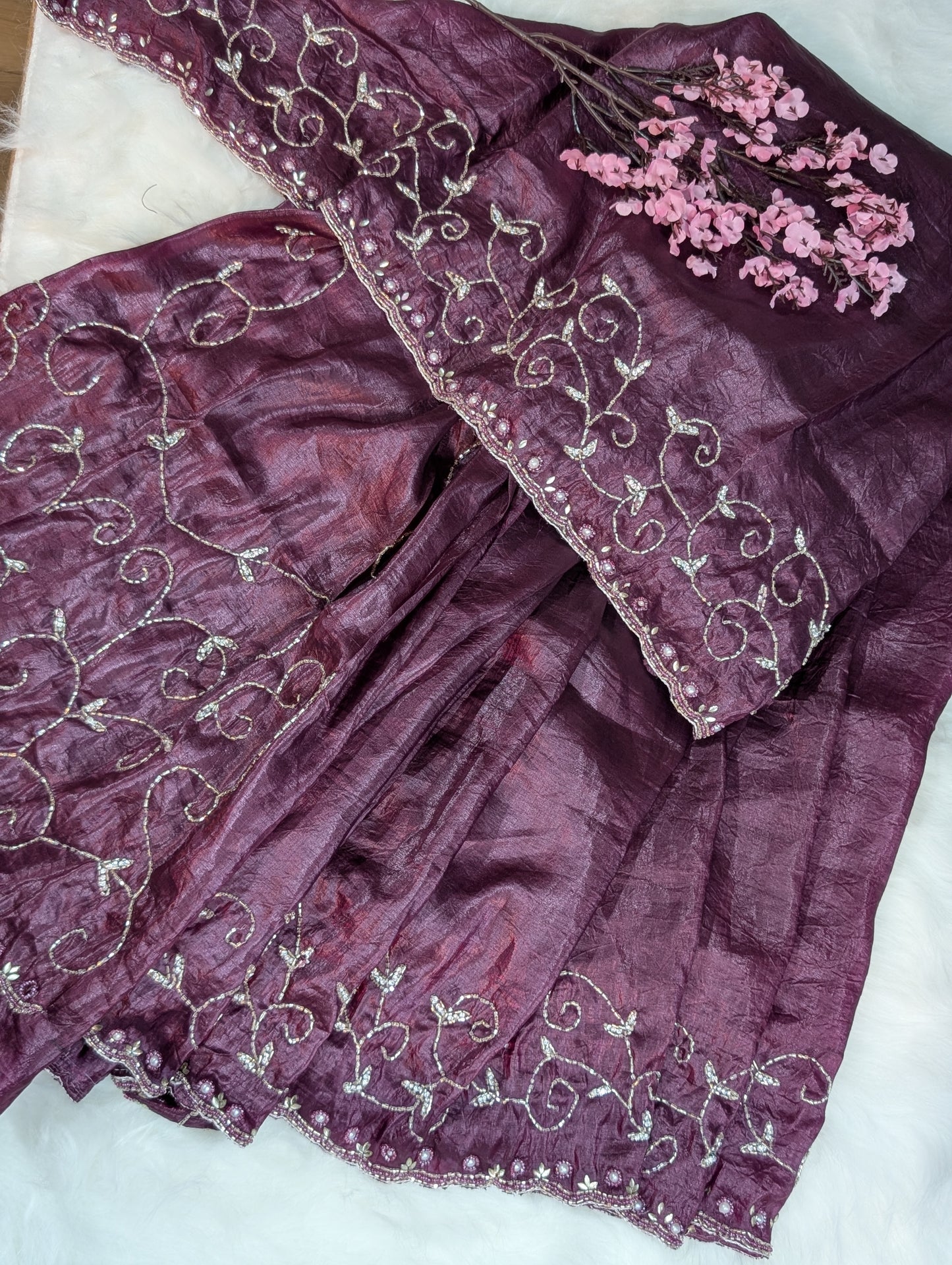 Purple fabric with intricate silver embroidery on a white background