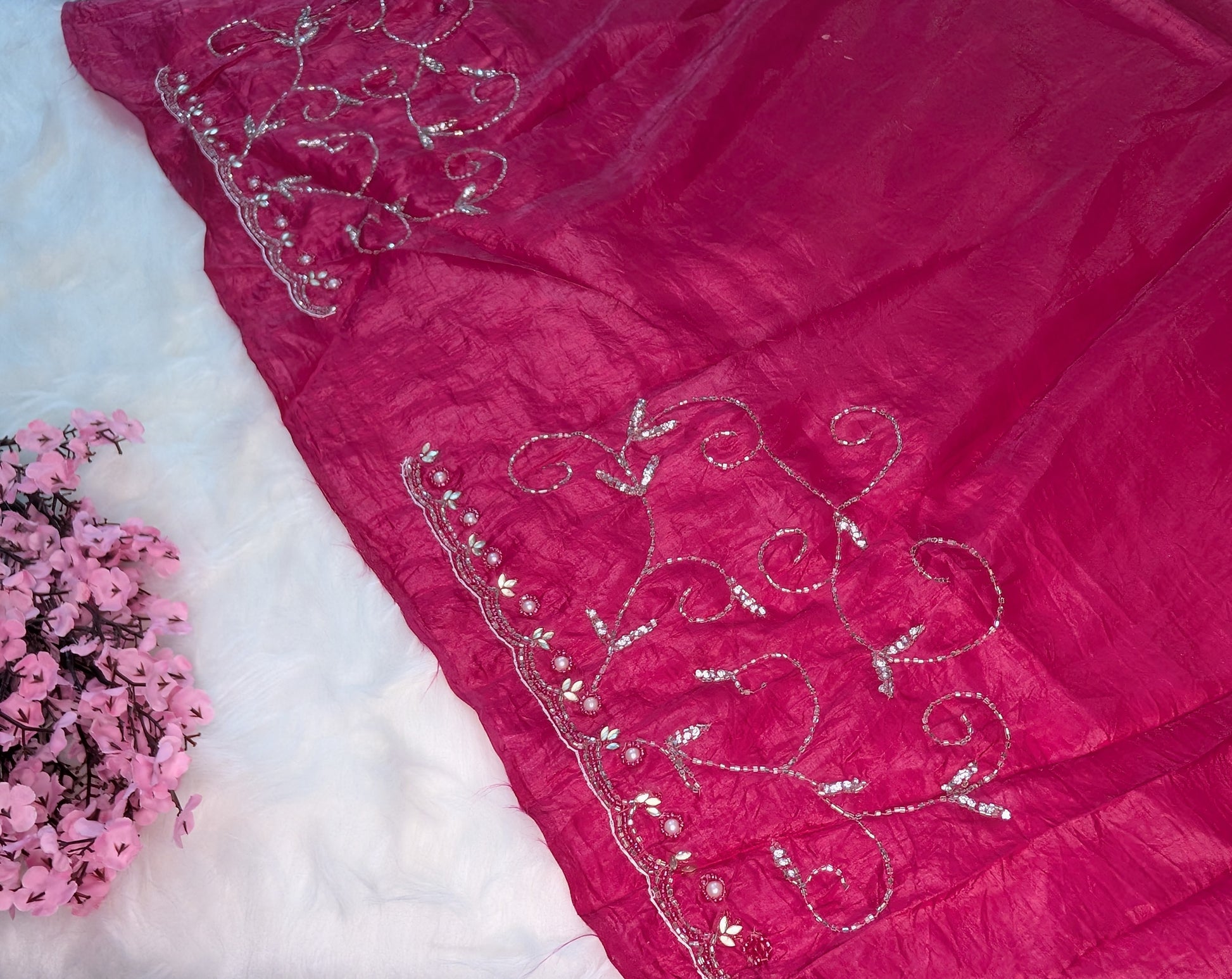 Pink fabric with silver embroidery on a white background